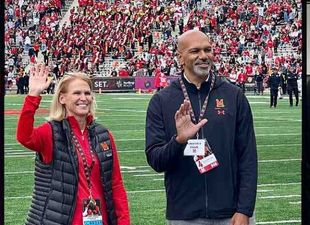 two faculty standing on football field