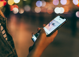 student holding cellphone with app