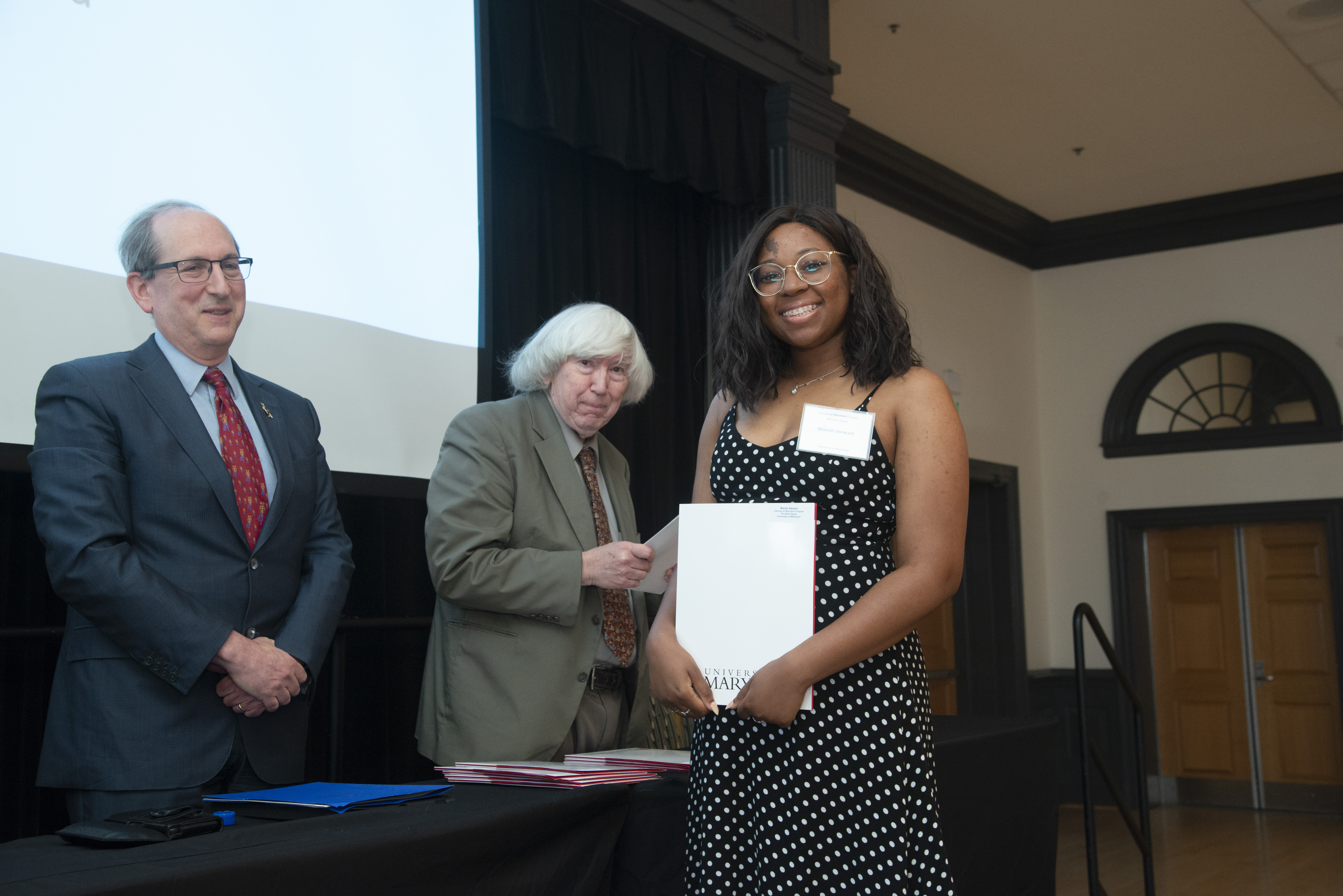 A newly inducted PBK member receives their certificate