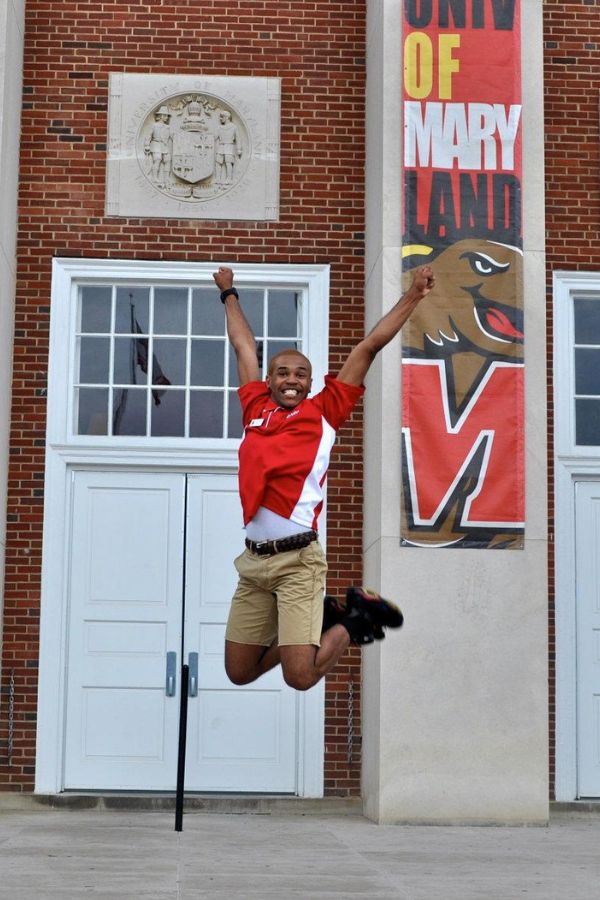 student jumping in air in front of armory building